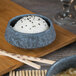 A Biseki blue stoneware bowl filled with rice and black sesame seeds on a table.