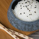 A 10 Strawberry Street Biseki stoneware bowl filled with rice next to chopsticks.