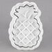 A white plastic pineapple shaped cookie cutter.