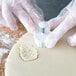 A person using an Ateco pineapple pastry cutter to make a cookie.