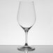 A clear Chef & Sommelier Bordeaux wine glass on a table with a reflection.