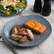 A rectangular blue stoneware dinner plate with food on it and a fork.