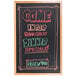 An Aarco oak-framed black chalk board with colorful writing that says "Come in and enjoy the sunflower dinner specials"