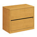 A HON wood lateral filing cabinet with two drawers.