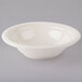 A Tuxton eggshell china pasta bowl on a gray surface.