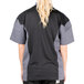 A person wearing a Chef Revival grey and black short sleeve chef jacket with mesh back.