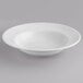 A Tuxton bright white embossed pasta bowl on a gray surface.