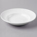 A Libbey Basics bright white porcelain soup bowl on a grey surface.
