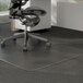 A black office chair on a Universal clear cleated low pile carpet chair mat.