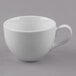 A Libbey Basics bright white porcelain low cup with a handle on a gray surface.