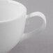 A close-up of a Libbey bright white porcelain low cup with a handle.