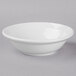 A Libbey Basics bright white porcelain grapefruit bowl on a gray surface.