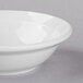 A close-up of a Libbey Basics white porcelain grapefruit bowl with a white rim.