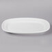 A Libbey Basics bright white porcelain racetrack plate on a gray background.