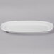 A close up of a Libbey Bright White oval porcelain racetrack platter with a small rim.