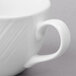 A close-up of a Libbey bright white porcelain coffee cup with a handle.