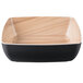 A square black melamine bowl with a wood grain pattern on the bottom.