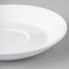 A Libbey bright white porcelain saucer on a gray surface.