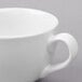 A close-up of a Libbey bright white porcelain low cup with a handle.