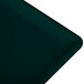A close-up of a Hunter Green rectangular cast aluminum cooling platter on a green surface.