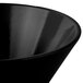 A close-up of a Tablecraft black cast aluminum serving bowl with a curved bottom.