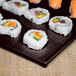 A sushi roll on a Tablecraft Midnight Speckle rectangular platter.