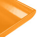 An orange Tablecraft cast aluminum rectangular platter on a yellow surface.