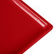 A red Tablecraft cast aluminum half long rectangular cooling platter with a handle.