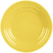 A close-up of a Fiesta Sunflower luncheon plate with a white circular pattern and a yellow rim.