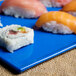 A Tablecraft blue speckle rectangular metal cooling platter with sushi on it.