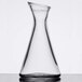 A clear glass Stolzle carafe with a small amount of liquid.