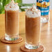 Two glasses of brown liquid sweetened with Torani Sugar-Free Sweetener with whipped cream and almonds.