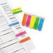 A sheet of paper with several Redi-Tag SeeNotes in assorted neon colors on it.