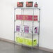 A Metro Super Erecta wire shelving unit with a green and white box, a purple box with black text, and several other boxes on it.