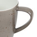 A close up of a light gray Schonwald porcelain coffee mug with a speckled design.