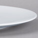 A Schonwald round white porcelain plate with a small rim.