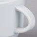 A close up of a white Schonwald Stacking Cup with a handle.