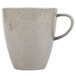 A white Schonwald porcelain cup with brown specks on the surface.