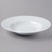 A Schonwald white porcelain bowl with a white rim on a gray surface.