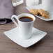 A white Schonwald espresso cup filled with brown liquid on a saucer with cookies.