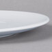 A Schonwald white porcelain coupe plate with a rim.