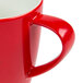 A close up of a red Schonwald porcelain mug with a white background.