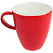 A Schonwald red porcelain coffee mug with speckled design and a red handle.