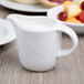 A Schonwald white porcelain creamer with a handle.