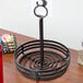 A black wrought iron condiment caddy with a place card holder.