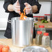 A chef putting carrots into a Vollrath aluminum stock pot.