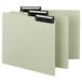 A group of green Smead file guides with black metal tabs.