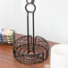 A black wrought iron condiment caddy with a card holder on a table.