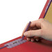 A person's hand holding a purple Smead SafeSHIELD classification folder with a pen.