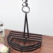 A black wrought iron half round condiment caddy with a table number holder.